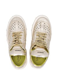 Metallische gouden sneakers met geperforeerd ontwerp, voorzien van gouden veters en een witte rubberen zool. Binnenin gevoerd met felgroen. Logo zichtbaar op de tong.