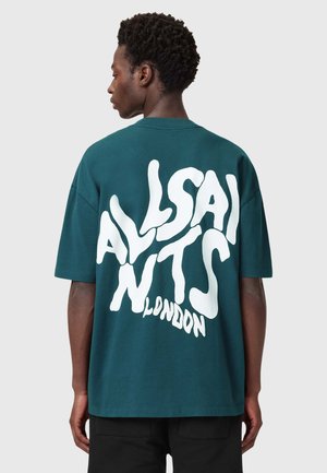 T-shirt in cotone oversize color teal con un audace design grafico bianco sul retro con la scritta "ALLSAINTS LONDON". Maniche corte e scollo rotondo.