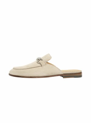 Beige ruskind slip-on mule med sølv metalbits-detalje, lav stakket hæl og afrundet firkantet tådesign på hvid baggrund.
