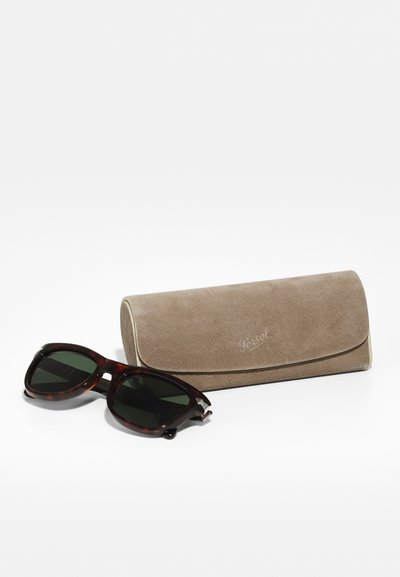 Tortoise shell päikeseprillid roheliste läätsedega, ümar forma ja hõbedased aktsendid. Kaasas beež suede kott.