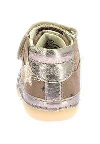 Zapato de ante marrón con acentos metálicos plateados, un diseño de estrella, correa de velcro y suela de goma ligera. Presenta detalles de costura y etiqueta interior.