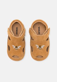 Brune semskede sandaler til barn med utskårne former, med en brodert bie-design på forsiden og en myk innerforing.