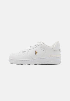 Baskets basses blanches en cuir avec fermeture à lacets, perforations près des lacets et logo Polo Ralph Lauren doré sur le côté.