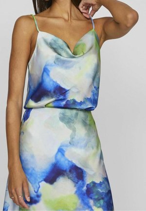 Bluzka i sukienka z kołnierzem typu cowl z lekkiego materiału, zdobione abstrakcyjnym wzorem w odcieniach niebieskiego, zielonego i białego, posiadające cienkie ramiączka i swobodny, luźny krój.