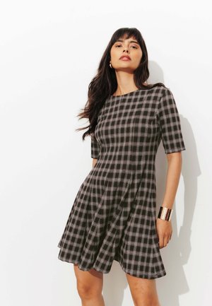 Robe à carreaux noir et blanc avec des manches courtes et une jupe évasée. Présente un col rond et une texture lisse.