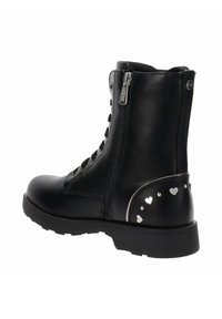 Botín negro de cuero hasta el tobillo con cremallera lateral, cordones y tachuelas metálicas en forma de corazón y redondas de color plata en el tacón.
