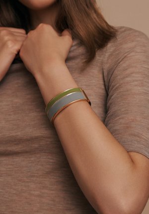 Gold-tone cuff bracelet with two horizontal bands, one green and one gray, featuring a smooth finish and a rectangular shape.