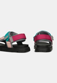 Sandali multicolore con una combinazione di cinturini rosa, turchesi e grigi, chiusure regolabili e suole in gomma nera robusta.