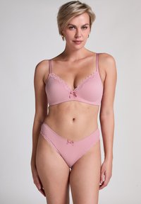 Pink ribbed Lingerieset mit einem Bralette mit Spitze und einer dekorativen Schleife, ergänzt durch passende Unterwäsche mit Spitzenrand.