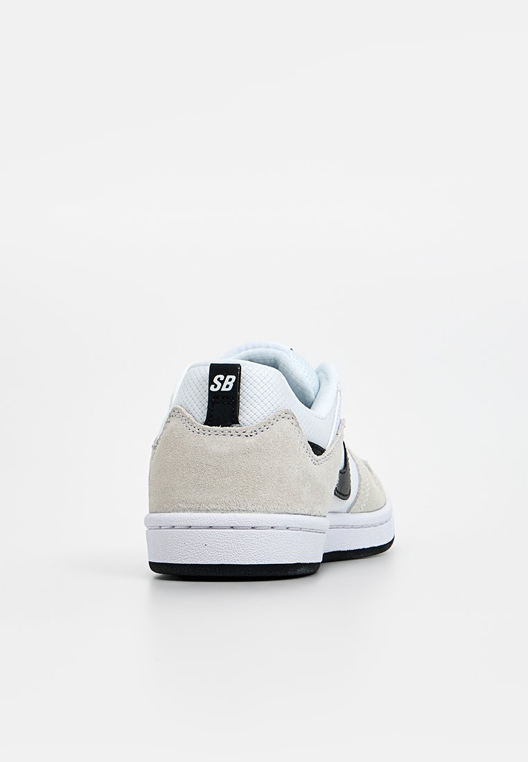 Sneaker mit einem hellgrauen Obermaterial aus Wildleder, weißer Netz-Zunge, schwarzem Swoosh und Gummisohle. Verfügt über ein SB-Logo an der Ferse.