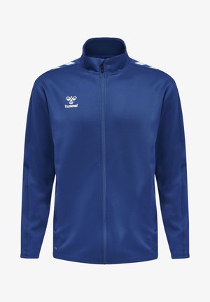 Chaqueta deportiva azul hecha de tela suave, presenta un cierre completo, cuello alzado, dos bolsillos laterales y logo y rayas blancas en los hombros.