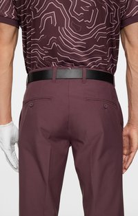 Bordowe spodnie o eleganckim kroju i gładkiej fakturze, z czarnym paskiem, tylnymi kieszeniami i wzorzystą koszulą na górze.
