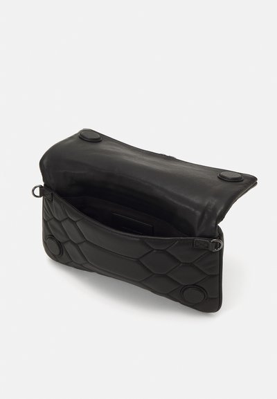 Black leather bag with a quilted pattern, magnetic closure, and a single interior pocket. Textured exterior with round accents.