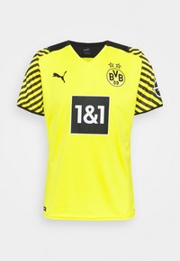 Gul fotbollströja med v-ringning, svarta detaljer, randiga ärmar och logotypen "BVB 09" med två stjärnor. Svart rektangulärt sponsormärke.