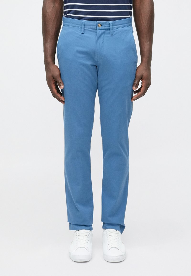 Ανοιχτό μπλε chino παντελόνι με λείο ύφασμα από βαμ�βακερό μείγμα, διαθέτει κλασική ίσια γραμμή, εμπρόσθιες τσέπες και ένα κουμπί στο κλείσιμο.