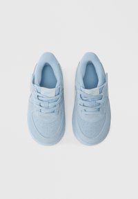 Lyseblå joggesko med overdeler i semsket skinn og tekstil. Rundt tåparti, perforerte detaljer og flate lisser. Logo på tungen, myk polstring på innsiden.