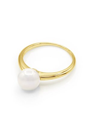 Bague en or avec une grande perle blanche montée sur une alliance lisse et polie, présentée sur un fond blanc.