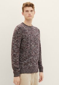Stickad tröja i mörkröd och gråmelerad mönster, rund halsringning, ribbade ärmslut och nederkant. Mjuk textur, normal passform, långärmad.