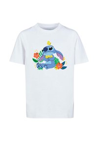 Bílý bavlněný tričko s modrou karikaturou obklopenou barevnými květinami a rostlinami se žlutými akcenty. Design s krátkým rukávem.