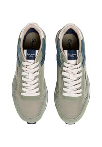 Baskets vertes et beiges avec une tige en suède et mesh, avec un accent bleu foncé, des lacets crème et une semelle noire. Logo visible sur la languette.