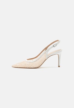 Beige pointed-toe slingback high heel with white floral lace overlay and white adjustable ankle strap.