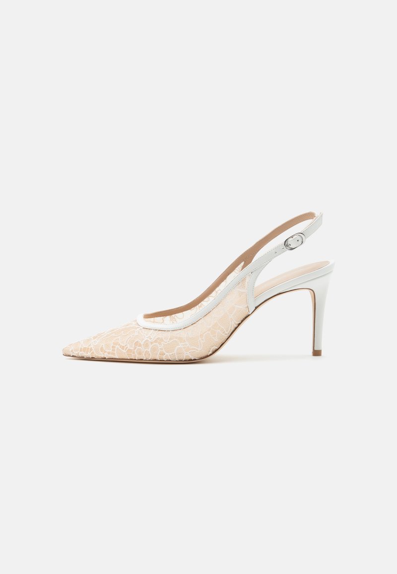 Escarpin slingback beige à bout pointu avec superposition de dentelle florale blanche et bride de cheville blanche réglable.