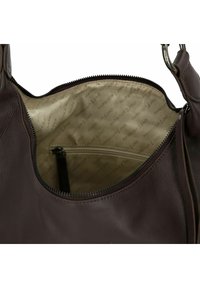 Bruine leren handtas met ritsluiting, voorzien van een beige binnenvoering met herhaaldelijke branding en een klein ritsvakje.