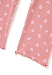 Leggings de color rosa con relieve y patrones de corazones rosa claro dispersos, con un detalle de volantes en el dobladillo de la parte inferior de las piernas.
