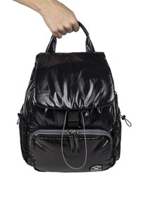 Mochila acolchada negra con un acabado brillante, cierre de doble cremallera, asa superior y bolsillos de malla laterales. Presenta un parche de logo en la parte frontal.