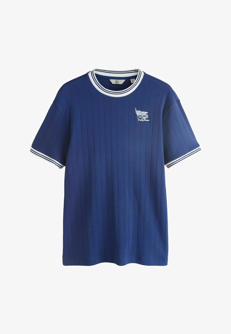 T-shirt bleu à manches courtes en tissu côtelé avec col et poignets rayés blancs, comportant un petit drapeau blanc brodé et un texte sur le côté gauche de la poitrine.