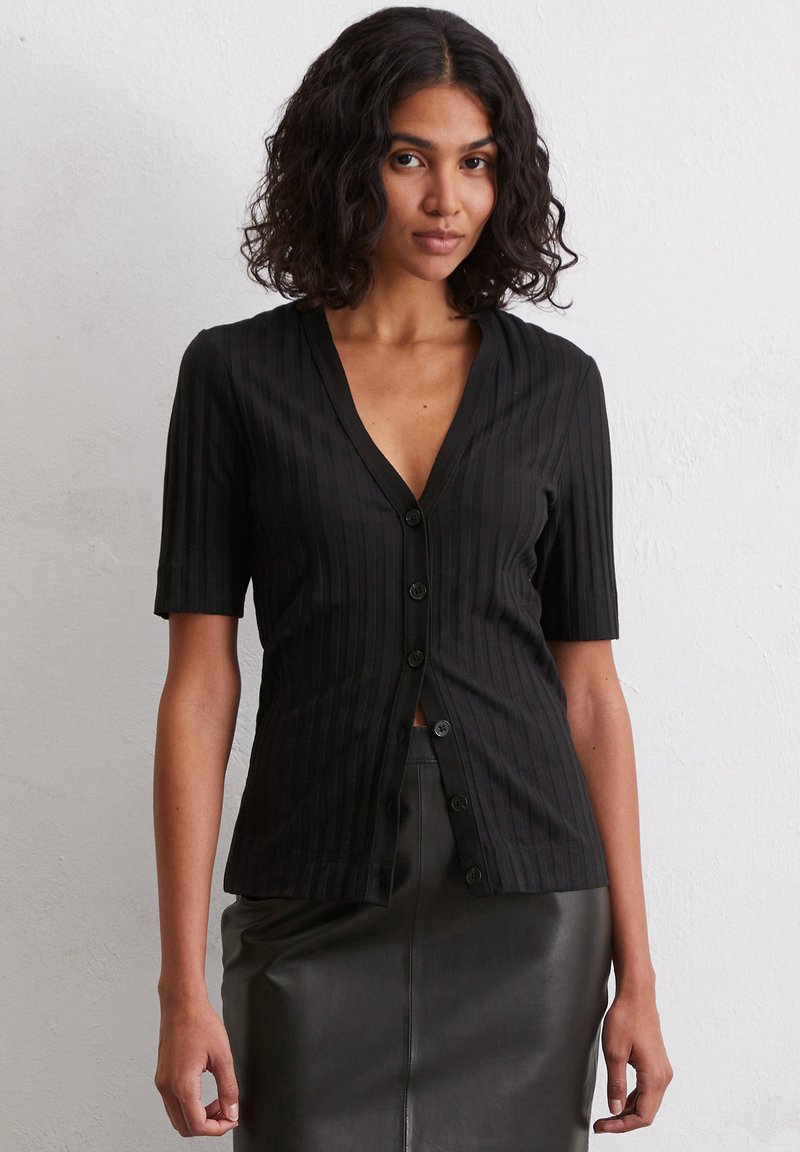 Schwarze, gerippte Kurzarm-Cardigan mit V-Ausschnitt, ausgestattet mit einer Reihe schwarzer Knöpfe auf der Vorderseite. Glatte Textur, lockere Passform.