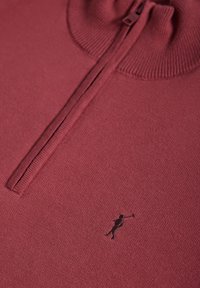Pull en maille bordeaux avec col demi-zip côtelé et petit logo de joueur de polo brodé en noir sur la poitrine.
