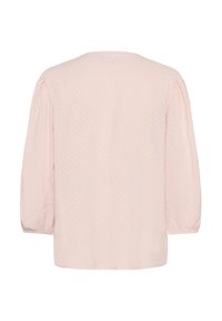 Lyserød bluse med trekvartærmer, struktureret stof og rund udskæring. Har et diskret prikmønster hele vejen igennem.