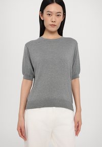 Grå kortermet genser laget av myk strikket materiale, med rund hals og avslappet passform, samt ribbestrikkede mansjetter og nederkant.