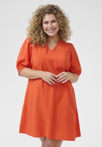 Sukienka z krótkim rękawem, do kolan, w jasnym pomarańczowym kolorze, z dekoltem w kształcie litery V oraz teksturowaną tkaniną, z marszczonymi rękawami i luźnym krojem.