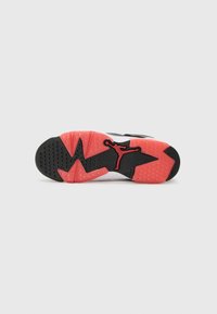 Sorte og rosa sneakersåle med et karakteristisk grep m�ønster, sirkulære gripepunkter, og en fremtredende rød Jumpman-logo.