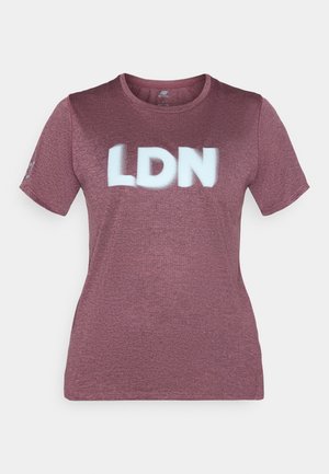 Marenā t-krekls no faktūrēta auduma ar īsām piedurknēm. Uz krūtīm lielajiem baltiem burtiem ir uzraksts "LDN". Noapaļots kakla izgriezums.