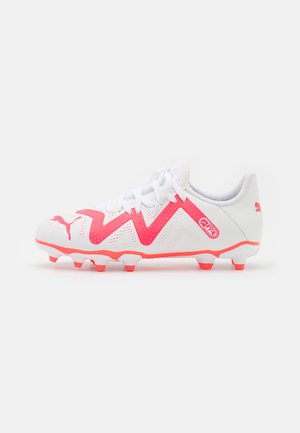 Scarpa da calcio bianca con accenti zigzag rosa, texture perforata e lacci bianchi. Presenta un logo sul lato e numerosi coni di trazione.