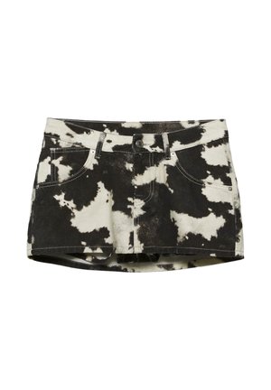 Černobílá mini džínová sukně s potiskem kravího vzoru, s předními knoflíky, zipem, poutky na pásek a kapsami na bílém pozadí.