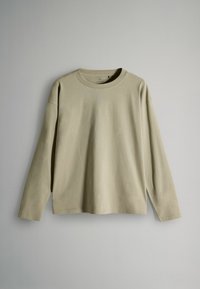 Beige long-sleeve crewneck shirt hanging flat against a plain light gray background.