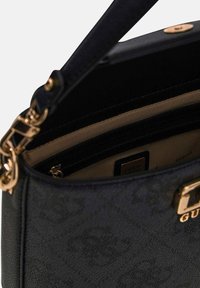 Strukturalna torebka wykonana z czarnego, teksturowanego materiału syntetycznego, wyposażona w złote okucia i jasno-beżowe wnętrze z wieloma kieszeniami.