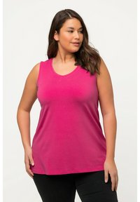 Fuchsia mouwloze top van katoen, met een ronde hals en een ontspannen pasvorm, gecombineerd met donkere broeken in een eenvoudige uitvoering.