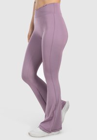 Wysokie, fioletowe legginsy do jogi wykonane z elastycznego materiału, z gładką fakturą, rozszerzającymi się nogawkami i płaskimi szwami dla wygody.