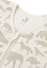 Katoenen slaappak in crème met lichtgroene dierenprints, voorzien van een rits aan de voorkant en een zachte textuur. Maatlabel: 70 cm.