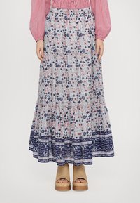 Floral Maxi-Rock in Hellblau mit roten und marineblauen Mustern, mit gestuftem Rüschendesign, elastischem Taillenbund, kombiniert mit tanfarbenen Plateau-Sandalen.