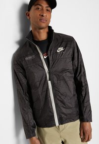 Nike Sportswear Corta-vento - anthracite/light bone