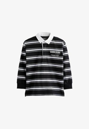 Juodai baltos dryžuotos ilgomis rankovėmis polo marškiniai su balta apykakle. Ant priekinės dalies yra tekstas: "PRENUMERUOK" ir papildomos grafinės detalės.