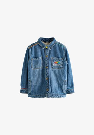 Kék farmerdzseki, elöl két zsebbel, gombos záródással és színes varrási részletekkel. A bal zseben egy szivárványos grafika található.