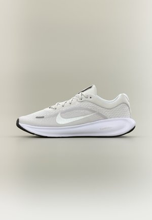 Zapatilla de running Nike blanca con parte superior de malla, suela acolchada y suela exterior negra, mostrada de perfil sobre un fondo neutro.