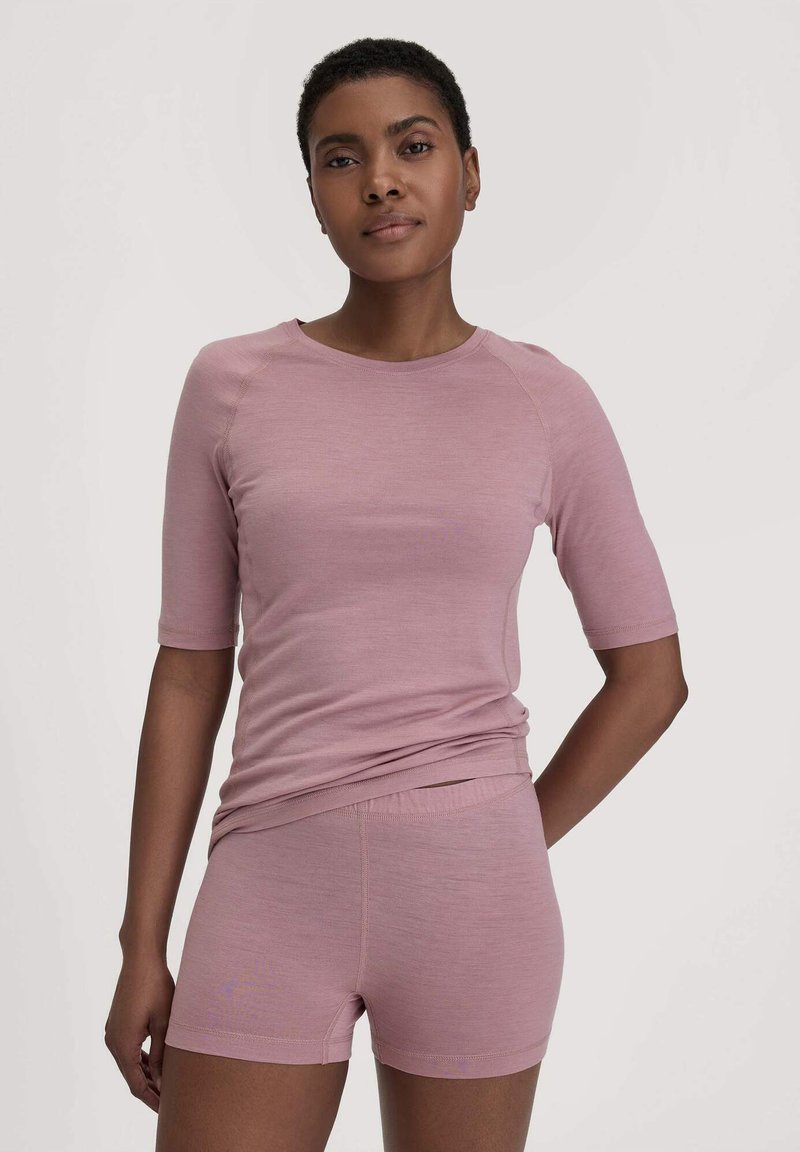 Lichtroze, getailleerde top met korte mouwen en bijpassende shorts van zacht materiaal met een gladde textuur; naadloos ontwerp, minimalistische stijl.